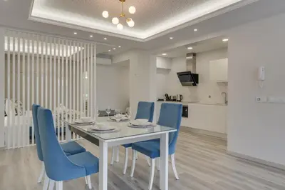 a dining room with a white table and blue chairs at Torre Palace II by Atlantic Holiday in Câmara de Lobos