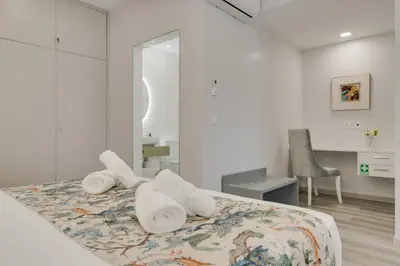 a white bedroom with towels on a bed at Torre Palace II by Atlantic Holiday in Câmara de Lobos