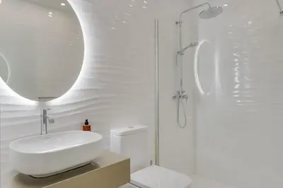 a white bathroom with a sink and a shower at Torre Palace II by Atlantic Holiday in Câmara de Lobos