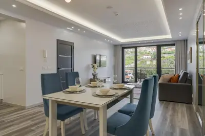 a dining room with a table and blue chairs at Torre Palace II by Atlantic Holiday in Câmara de Lobos
