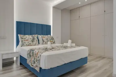 a bedroom with a large bed with a blue headboard at Torre Palace II by Atlantic Holiday in Câmara de Lobos