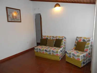 a living room with two chairs and a wall at Monte Chabouco - Alojamento Local in Chabouco