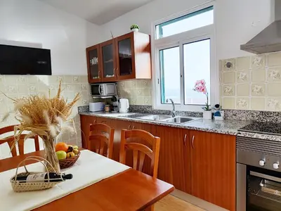 a kitchen with a table with a bowl of fruit on it at GATEONE AL Airport View House in Machico