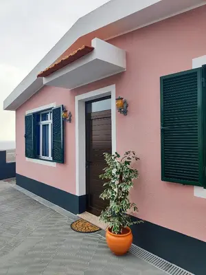 a pink house with a plant in front of it at GATEONE AL Airport View House in Machico
