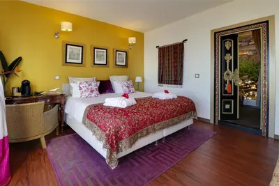 a bedroom with a bed and a desk and a window at Dazkarizeh73 in Ribeira Brava