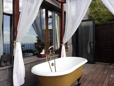 a bath tub sitting on a deck with a window at Dazkarizeh73 in Ribeira Brava