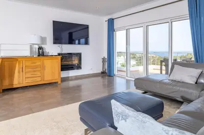 a living room with a couch and a tv at Villa Céu Do Sul in Burgau
