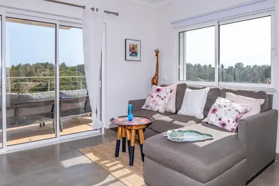 a living room with a couch and a table at Villa Céu Do Sul in Burgau