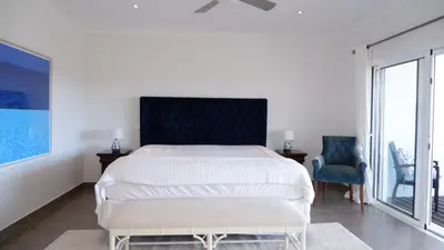 a bedroom with a bed and two chairs and a window at Villa Céu Do Sul in Burgau