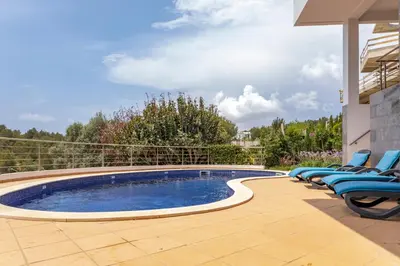 a swimming pool with lounge chairs next to a house at Villa Céu Do Sul in Burgau