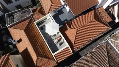 an overhead view of a building with a white umbrella at Fisherhouse23 in Câmara de Lobos