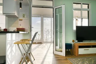 a kitchen with a table and a television in a room at Atlantic View, a Home in Madeira in Ponta do Sol