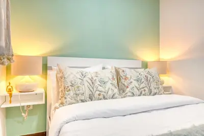 a bedroom with a white bed and two lamps at Atlantic View, a Home in Madeira in Ponta do Sol
