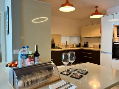 a kitchen with two glasses and wine bottles on a table at Southern Skies Apartment in Funchal