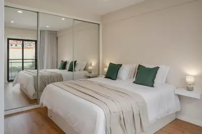 a bedroom with two beds and a large mirror at Santa Luzia III by An Island Apart in Funchal
