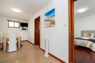 a bedroom with a bed and a table and a dining room at Atouguia House - Traditional House in Calheta