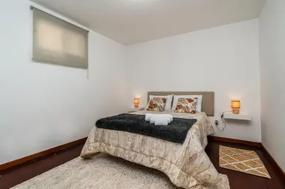 a bedroom with a bed and a flat screen tv at Atouguia House - Traditional House in Calheta