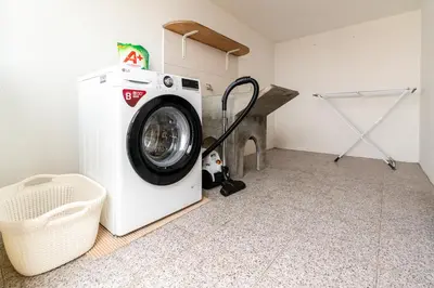a washing machine in a laundry room with a chair at Atouguia House - Traditional House in Calheta