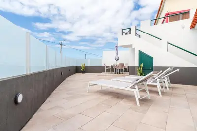 a balcony with chairs and a table on a building at Atouguia House - Traditional House in Calheta