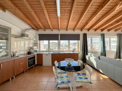 a kitchen and living room with a table and a couch at Refúgio na Praia de Burgau #1947 in Burgau