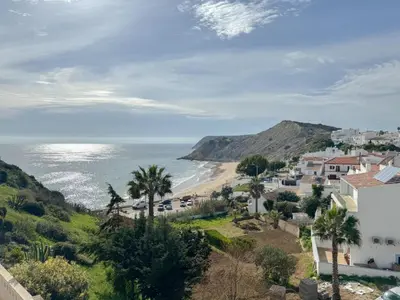 a view of a beach with palm trees and houses at Refúgio na Praia de Burgau #1947 in Burgau