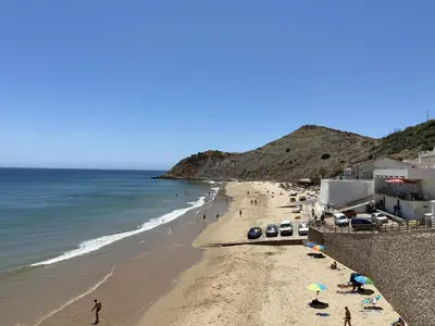 a beach with people on the sand and the ocean at Refúgio na Praia de Burgau #1947 in Burgau