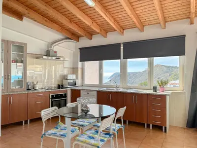 a kitchen with a table and chairs in a kitchen at Refúgio na Praia de Burgau #1947 in Burgau