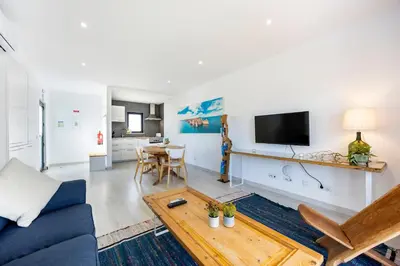 a living room with a blue couch and a table at Casa Epic in Sagres