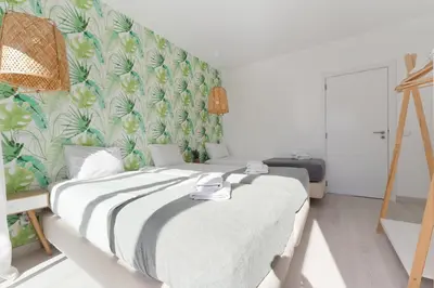 a bedroom with a large bed with a green wall at Casa Epic in Sagres