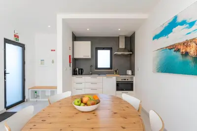 a kitchen with a wooden table with a bowl of fruit on it at Casa Epic in Sagres