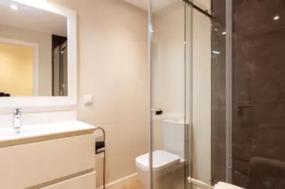 a bathroom with a toilet and a glass shower at The Jolie - Lava Pools Apartments in Porto Moniz