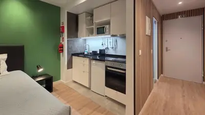 a kitchen with a bed and a stove top oven at The Jolie - Lava Pools Apartments in Porto Moniz