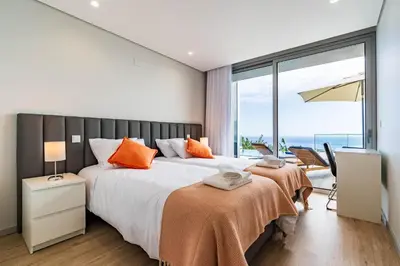a bedroom with a large bed and a large window at Villa Anita ,beautiful sunset in Arco da Calheta