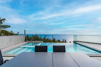 a swimming pool with a view of the ocean at Villa Anita ,beautiful sunset in Arco da Calheta