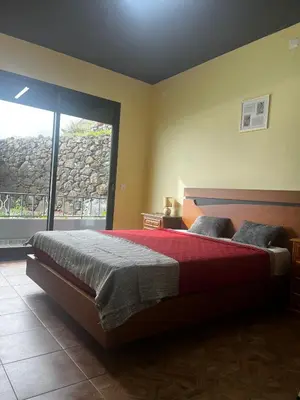 a bedroom with a bed and a large window at Fernanda's House in Ribeira Brava