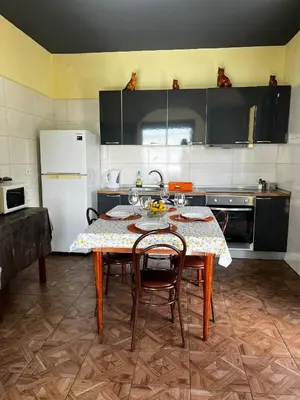a kitchen with a table with chairs and a refrigerator at Fernanda's House in Ribeira Brava