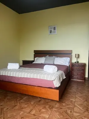 a bedroom with a large bed and a wooden floor at Fernanda's House in Ribeira Brava