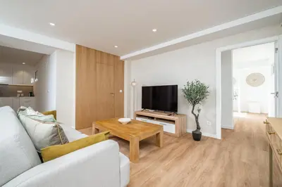 a living room with a couch and a tv and a table at Casa Magnólia in Funchal