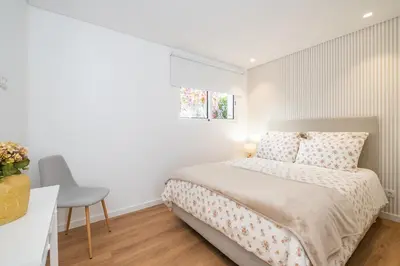 a bedroom with a bed and a desk and a window at Casa Magnólia in Funchal