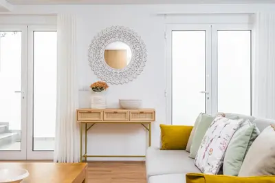 a living room with a couch and a table with a mirror at Casa Magnólia in Funchal