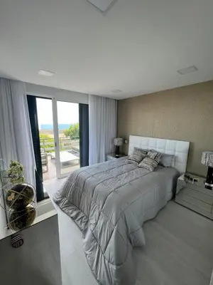 a white bedroom with a large bed and a window at Funchal Lido Belo Horizonte in Funchal
