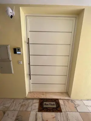a white garage door in a room with a tile floor at Funchal Lido Belo Horizonte in Funchal