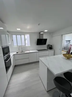 a white kitchen with a sink and a counter at Funchal Lido Belo Horizonte in Funchal