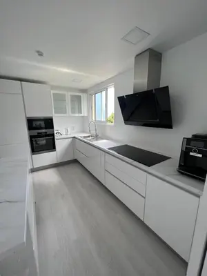a white kitchen with a sink and a stove at Funchal Lido Belo Horizonte in Funchal