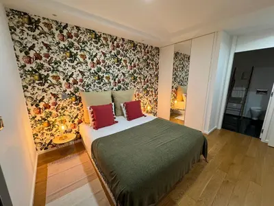 a bedroom with a large bed with a floral wallpaper at Carreira Residence in Funchal