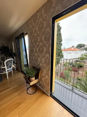 a room with a large window and a balcony at Carreira Residence in Funchal