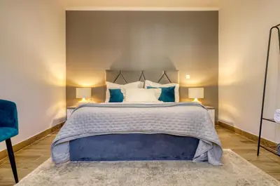 a bedroom with a large bed with blue pillows at Casa dos Anjos, a Home in Madeira in Faial