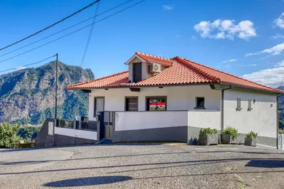 a house with a mountain in the background at Casa dos Anjos, a Home in Madeira in Faial
