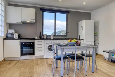 a kitchen with a table with a bowl of fruit on it at Casa dos Anjos, a Home in Madeira in Faial