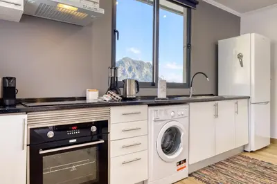 a kitchen with a washer and dryer in it at Casa dos Anjos, a Home in Madeira in Faial